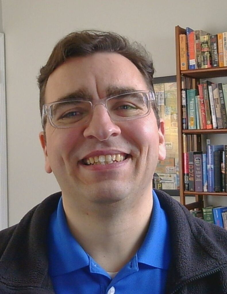 Profile picture of Dr. Zach Collins in front of a bookshelf